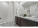 Dual sink bathroom featuring a shower-tub, dark wood vanity with modern fixtures at 236 Back Nine Dr, Castle Pines, CO 80108