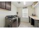 Functional laundry room with modern appliances, storage cabinets, and a workspace at 236 Back Nine Dr, Castle Pines, CO 80108