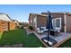 Cozy backyard space with artificial turf, concrete patio area with comfortable seating, and a sleek fire pit at 1772 Taos St, Brighton, CO 80603