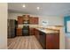 Open concept kitchen features stainless steel appliances, wood cabinets, and stylish wood flooring at 1772 Taos St, Brighton, CO 80603