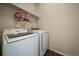 A well-lit laundry room featuring a new Samsung washer and dryer set, and upper shelving for storage at 1772 Taos St, Brighton, CO 80603
