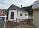 Charming home with white siding, blue trim, a black roof, and a colorful accent over the porch at 215 Colorado Blvd, Idaho Springs, CO 80452