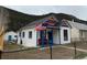 Charming white home with colorful accents, an American flag, and a cozy front porch at 215 Colorado Blvd, Idaho Springs, CO 80452