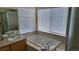 Bright bathroom featuring a soaking tub beneath large windows and a vanity with sink at 8024 W 95Th Way, Broomfield, CO 80021