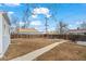 A spacious backyard with a long walkway, bordered by a wooden fence with a utility pole visible above at 1780 S Umatilla St, Denver, CO 80223
