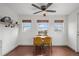 Charming dining area with three windows and wood floors, featuring a ceiling fan and table with bright yellow chairs at 1780 S Umatilla St, Denver, CO 80223