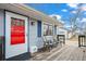 Cozy front porch, featuring a bright red door and chairs for relaxing at 1780 S Umatilla St, Denver, CO 80223