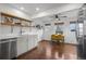 Bright kitchen with stainless steel appliances, open shelving and adjacent dining area with three windows and wood floors at 1780 S Umatilla St, Denver, CO 80223