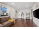 Bright living room featuring hardwood floors, neutral walls, and stylish shelving at 1780 S Umatilla St, Denver, CO 80223