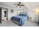 Bright bedroom with a comfortable bed, neutral carpet, and natural light. Another room can be seen in the background at 1780 S Umatilla St, Denver, CO 80223