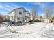 Spacious backyard with a patio, outdoor furniture, shed, and a layer of snow in a residential neighborhood at 14558 Vine St, Thornton, CO 80602