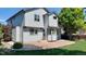 A two-story house in the backyard features a concrete patio and green grass at 14558 Vine St, Thornton, CO 80602
