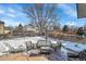 Cozy backyard patio setup with wicker furniture, snow covering yard, with surrounding neighborhood view at 14558 Vine St, Thornton, CO 80602