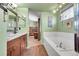 Spa-like bathroom featuring a soaking tub, granite vanity, and ceramic floors at 14558 Vine St, Thornton, CO 80602