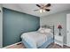 Bedroom with blue accent wall, ceiling fan, and bedside table at 14558 Vine St, Thornton, CO 80602