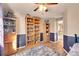 Bedroom featuring a blue accent wall, wood-look floors, and a large bookcase at 14558 Vine St, Thornton, CO 80602