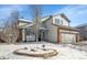 Charming two-story home with snowy landscaping and a brick accent on the garage at 14558 Vine St, Thornton, CO 80602