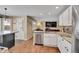 Bright kitchen featuring white cabinets, granite countertops, stainless steel appliances, and hardwood floors at 14558 Vine St, Thornton, CO 80602