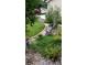 Landscaped area with a bench, flowerpots, greenery, and well-maintained lawn in front of a home at 14558 Vine St, Thornton, CO 80602