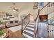 Bright foyer showcasing hardwood floors, a staircase, and living room with a ceiling fan at 14558 Vine St, Thornton, CO 80602