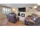 Warm living room features fireplace, TV, leather furniture, and hardwood flooring at 14558 Vine St, Thornton, CO 80602