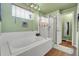 Spa-like bathroom with soaking tub, glass shower, and light green walls at 14558 Vine St, Thornton, CO 80602