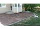 Outdoor patio with decorative compass design, steps leading to house, and white dog relaxing on the grass at 14558 Vine St, Thornton, CO 80602