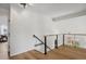 Loft with hardwood floors, modern railings, and natural light showcasing an open and airy design at 8174 Field Cir, Arvada, CO 80005