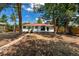 Backyard view of home featuring mature trees, covered patio, and spacious yard at 3338 W Arlington Ave, Littleton, CO 80123