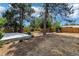 A concrete patio is surrounded by mature trees and a wooden fence at 3338 W Arlington Ave, Littleton, CO 80123