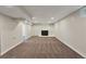 Finished basement area featuring a whitewashed brick fireplace, neutral carpet, and recessed lighting at 3338 W Arlington Ave, Littleton, CO 80123