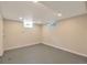 A clean, unfinished basement space features gray concrete floors and two small windows at 3338 W Arlington Ave, Littleton, CO 80123