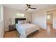 This bedroom features light hardwood floors, a ceiling fan, and a comfortable bed with stylish bedside tables at 3338 W Arlington Ave, Littleton, CO 80123