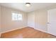 A bright bedroom with hardwood floors, white trim, a large window, and a closet for ample storage at 3338 W Arlington Ave, Littleton, CO 80123