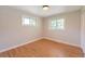 Inviting bedroom with hardwood floors, two windows for ample natural light, and neutral walls at 3338 W Arlington Ave, Littleton, CO 80123