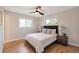 A cozy bedroom featuring hardwood floors, a ceiling fan, and natural light from a large window at 3338 W Arlington Ave, Littleton, CO 80123