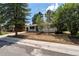 Charming home exterior with mature trees, a well-manicured lawn, and freshly painted brick at 3338 W Arlington Ave, Littleton, CO 80123