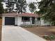 Charming exterior featuring a painted brick facade, modern black accents, and a well-maintained front yard at 3338 W Arlington Ave, Littleton, CO 80123