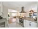 Open concept kitchen with white cabinets, stainless steel appliances, and granite countertops at 3338 W Arlington Ave, Littleton, CO 80123