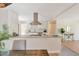 Open kitchen with a modern island, stainless steel hood, and bright lighting near the dining and living areas at 3338 W Arlington Ave, Littleton, CO 80123