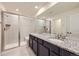 Bathroom with double sinks, granite countertop, and a shower with glass doors and a built-in bench at 17530 E 95Th Ave, Commerce City, CO 80022