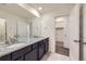 Bathroom featuring double sinks, granite countertops, and a view into the walk-in closet from the open doorway at 17530 E 95Th Ave, Commerce City, CO 80022