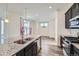 Kitchen showcases a granite countertop island, double sink, stainless steel appliances, and wood-look flooring at 17530 E 95Th Ave, Commerce City, CO 80022