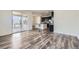 Open-concept living area with wood floors seamlessly flowing into the kitchen, perfect for modern living and entertaining guests at 17530 E 95Th Ave, Commerce City, CO 80022