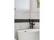 Elegant bathroom featuring sleek black fixtures and a modern soaking tub at 2317 S Galapago St, Denver, CO 80223