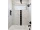 Modern bathroom featuring marble tiling, a sleek black showerhead, and a built-in window for natural light at 2317 S Galapago St, Denver, CO 80223