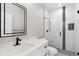 Sleek bathroom with white marble, frameless shower, quartz countertops, and modern black hardware at 2317 S Galapago St, Denver, CO 80223