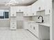 Bright kitchen featuring white cabinets, stainless steel hardware, white subway tile backsplash, and modern lighting at 2317 S Galapago St, Denver, CO 80223