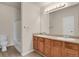 Bathroom with dual sinks, wood cabinets, and a shower-tub combo for a functional and stylish space at 1801 S Dunkirk St # 108, Aurora, CO 80017