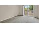 Bright bedroom with a sliding glass door to balcony, light-colored walls, and neutral carpeting at 1801 S Dunkirk St # 108, Aurora, CO 80017